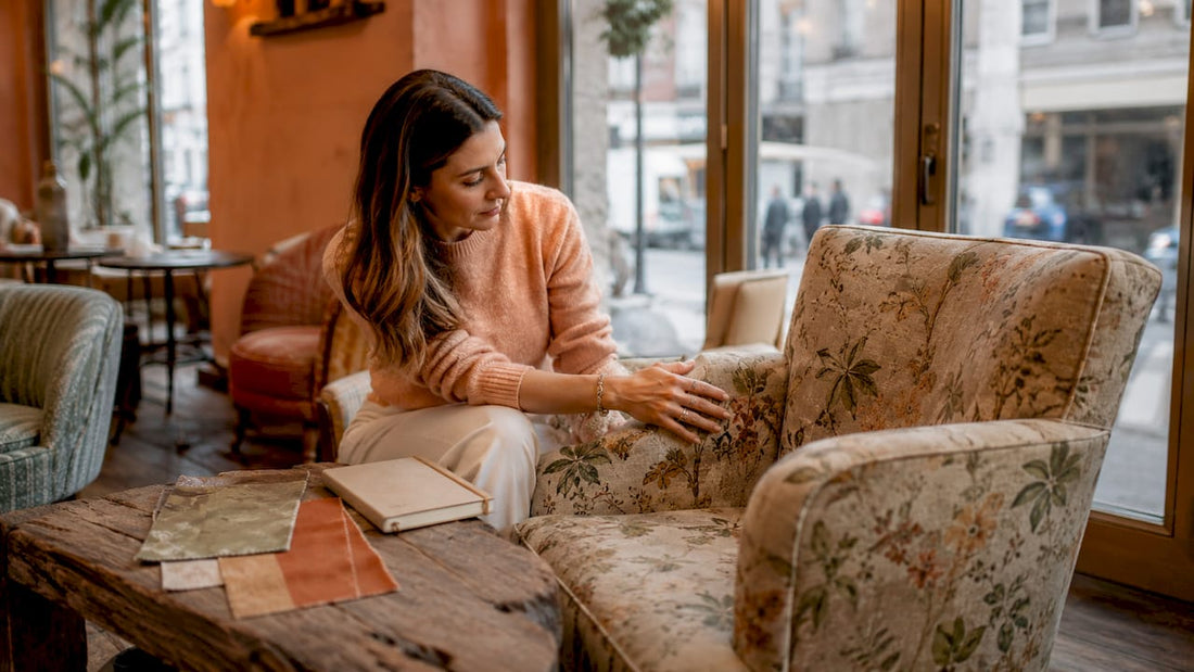 Woman examining floral upholstered sofa in showroom