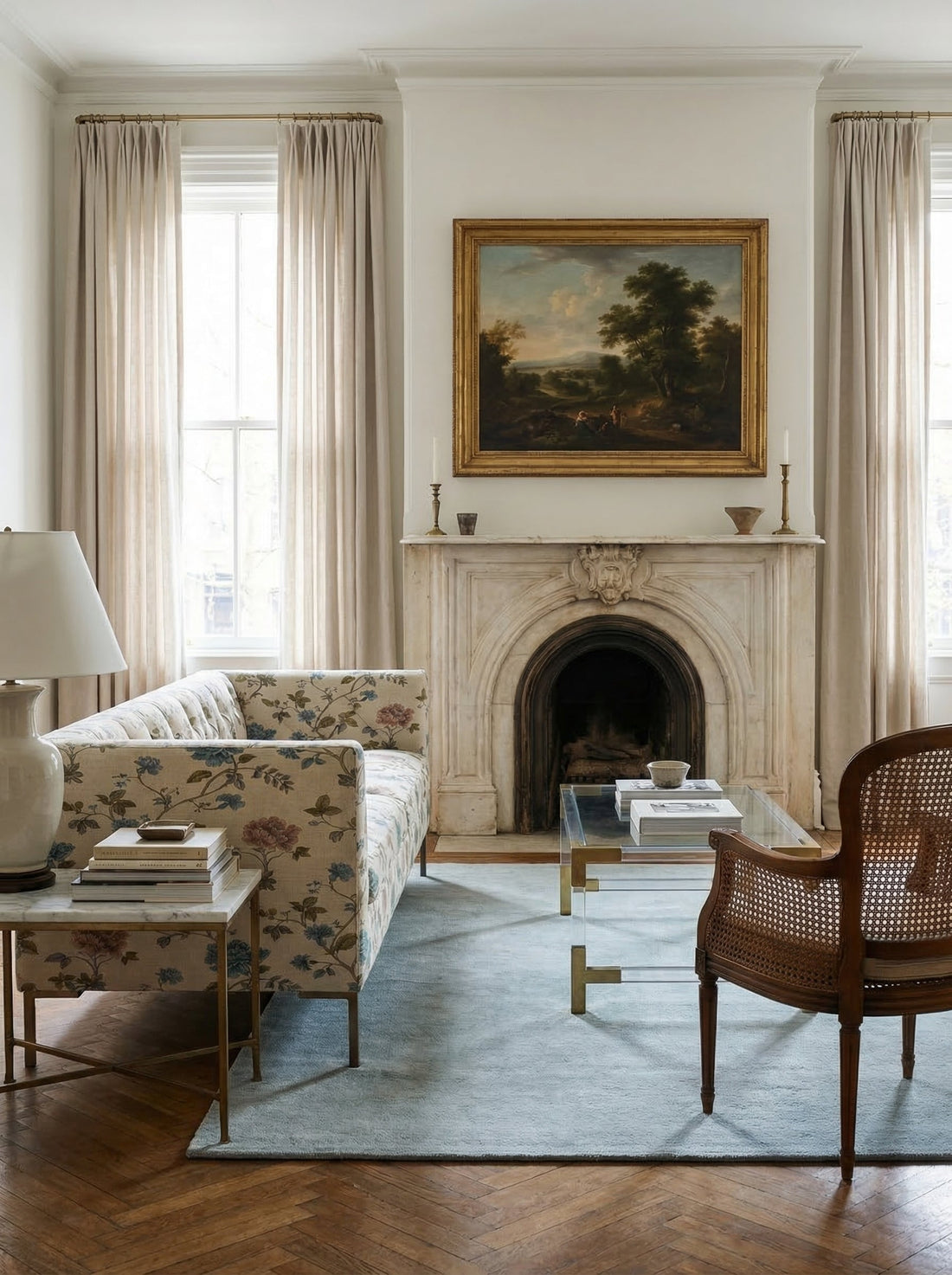 Floral chintz sofa in a neutral room with a plaster fireplace